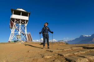 een jong reiziger trekking in poon heuvel visie punt in ghorepani, Nepal foto