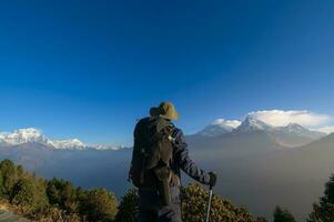 een jong reiziger trekking in poon heuvel visie punt in ghorepani, Nepal foto