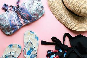 vlak leggen badmode Aan een roze achtergrond. kleding voor zomer vakantie. strandkleding. zomer reizen foto