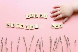 gelukkig moeders dag. moeders dag kaart. vlak leggen van houten brieven. kinderen hand- foto
