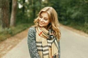 mooi jong vrouw in een elegant wijnoogst sjaal wandelingen in de park in herfst dag. foto