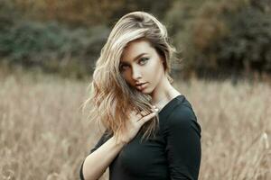 mooi jong vrouw in een zwart overhemd in de veld- met tarwe foto