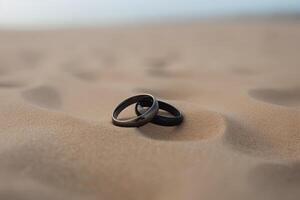 twee bruiloft ringen in de zand Aan de achtergrond van een strand en zee. ai gegenereerd foto