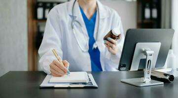medisch technologieconcept. arts die met mobiele telefoon en stethoscoop in modern bureau werkt foto