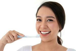mooi Aziatisch vrouw Holding een tandenborstel voor borstel tanden. haar is glimlach en tanden zijn wit en mooi en kijken hygiëne. concept voor mondeling en tandheelkundig zorg Aan de tandarts advies foto