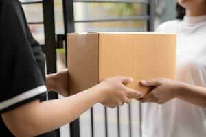 post- onderhoud Bezig met verzenden papier karton doos naar klant in voorkant van een huis buitenshuis. Verzending onderhoud aankomst en sturen naar klant adres. foto