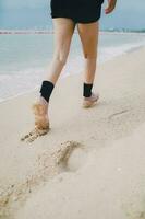 stap van vrouw been wandelen vooruit Aan zee strand foto