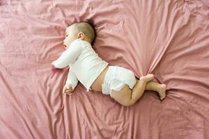 beeld van een pasgeboren baby aan het liegen Aan een roze bed foto