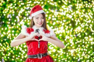 mooi Aziatisch meisje in de kerstman kostuum voor Kerstmis met nacht licht foto
