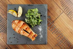 zalm vis steak met citroen en greens foto