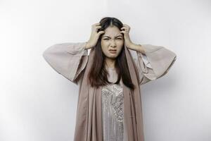 een portret van een Aziatisch moslim vrouw vervelend een hoofddoek geïsoleerd door wit achtergrond looks depressief foto