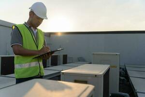 Aziatisch onderhoud ingenieur werken Aan de dak van fabriek. aannemer inspecteren compressor systeem en plannen installatie van lucht staat systemen in bouw. controlelijst, inspecteur, controle foto