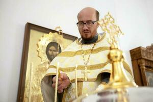 de priester lichten kaarsen. foto