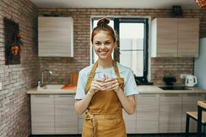 vrolijk vrouw in een schort in de keuken huiswerk modern stijl foto