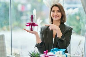 afbeelding van vrouw Holding een geschenk in restaurant foto