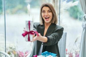 afbeelding van vrouw Holding een geschenk in restaurant foto