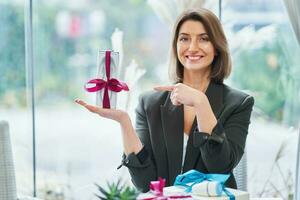 afbeelding van vrouw Holding een geschenk in restaurant foto