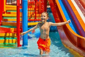 afbeelding van jong jongen spelen in buitenshuis aqua park foto