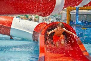 afbeelding van jong jongen spelen in buitenshuis aqua park foto