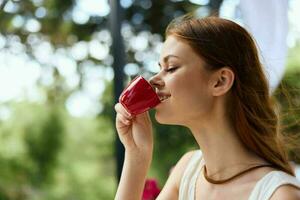 portret van jong mooi vrouw drinken koffie buitenshuis zomer dag foto