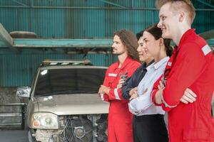 portret van zelfverzekerd managers en auto monteur team staand met armen gekruiste in een reparatie garage, auto reparatie en onderhoud concepten foto