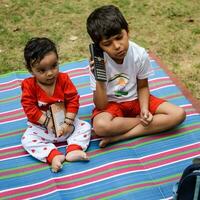 twee gelukkig jongens in maatschappij park, gelukkig Aziatisch broers wie zijn glimlachen gelukkig samen. broers Speel buitenshuis in zomer, het beste vrienden. kleuter baby jongen spelen met zijn gelukkig broer in de tuin foto