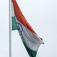 indiase vlag hoog op connaught plaats met trots in blauwe lucht, indiase vlag wapperen, indiase vlag op onafhankelijkheidsdag en republiek dag van india, tilt-up shot, wuivende indische vlag, har ghar tiranga foto