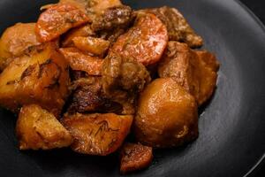 heerlijk vers gekookt stoofpot met varkensvlees vlees of rundvlees met aardappelen, wortels, specerijen en kruiden foto