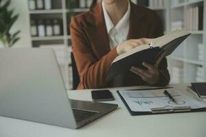 aantrekkelijk glimlachen jong Aziatisch bedrijf vrouw werk Bij huis kantoor, Aziatisch vrouw werken Aan laptop computer Holding tablet. foto