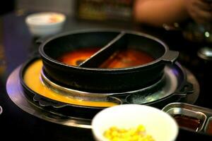 Koken soep in een Koreaans pot met smelten schaken en ei en zoet maïs in kop foto