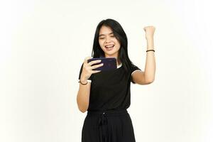 glimlachen en spelen mobiel spel Aan smartphone van mooi Aziatisch vrouw geïsoleerd Aan wit achtergrond foto