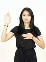 vloeken gebaar, maken een eed van mooi Aziatisch vrouw geïsoleerd Aan wit achtergrond foto