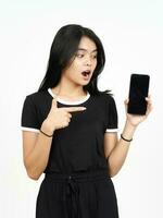 tonen blanco smartphone scherm met geschokt gezicht van mooi Aziatisch vrouw geïsoleerd Aan wit foto
