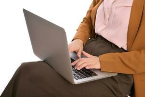 dichtbij omhoog van een bedrijf vrouw gebruik makend van laptop Aan haar ronde terwijl zittend foto