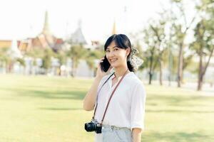 portret mooi jong Aziatisch vrouw met smartphone Aan zomer vakantie vakantie reis met de groots paleis in een achtergrond Bij Bangkok, Thailand foto