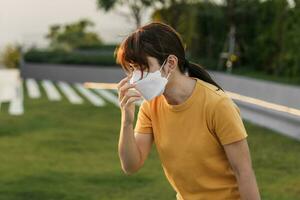 jong Aziatisch vrouw vervelend n95 ademhalings masker beschermen en filter pm2.5 of fijnstof er toe doen tegen slecht lucht verontreiniging in stad. lucht kwaliteit inhoudsopgave, aqi, ongezond, gezondheidszorg concept foto