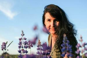 portret van een jong vrouw in Purper bloemen. zomer levensstijl foto