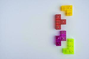 driedimensionaal gekleurde Tetris figuren Aan een wit achtergrond, ruimte voor kopiëren foto