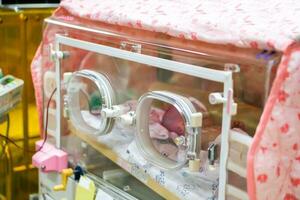 ziek pasgeboren baby slapen in een baby incubator in een ziekenhuis. foto