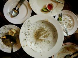 gerechten zijn geknoeid omhoog na aan het eten Aan de tafel. foto