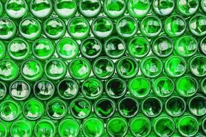 glas flessen groente. groen glas flessen van bier. muur gevormd door groen flessen. groen flessen achtergrond. leeg glas fles met verlichting foto