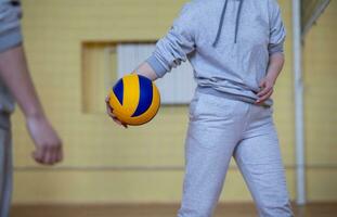 man's handen houden een volleybal.volleybal in de Sportschool. foto
