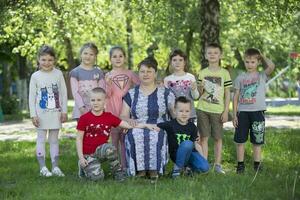 een groep van Russisch kinderen van kleuterschool met een leraar in de zomer tuin.kleuterschool leraar en kinderen foto