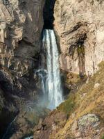 toneel- herfst landschap met verticaal groot sultan waterval Bij berg top in zonneschijn in de jila-su traktaat. Kabardië-Balkarië. Rusland, Kaukasus. hoog vallend water in noordelijk elbrus regio. foto