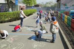 kleuterschool Open dag.kinderen van kleuterschool trek met kleurpotloden Aan de asfalt. foto