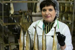 september 18, 2020. Wit-Rusland, gamil. vis fabriek.vis fabriek arbeider houdt gerookt vis. foto