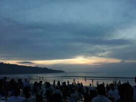 Jimbaran, Bali in mei 2018. zonsondergang Bij een plaats Aan Bali's Jimbaran strand. veel van mensen waren Bij de restaurants Aan de strand. foto