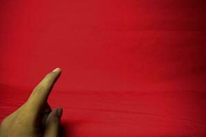 hand- met vinger gehouden omhoog Aan de rood achtergrond foto