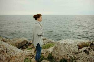 portret van een vrouw strand toerisme bewolkt weer steen kust ongewijzigd foto