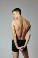 knap Mens met gemotiveerd omhoog arm spieren naakt terug grijs achtergrond model- foto